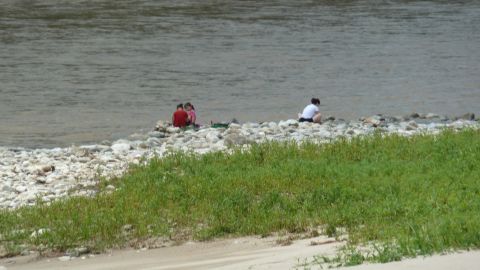 A North Korean family crouches by the river in Hyangsan, three hours from Pyongyang.