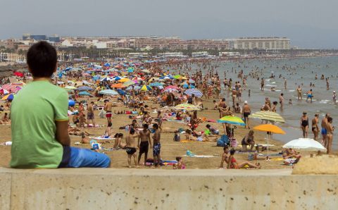 A boy takes in the scenery at Malvarrosa Beach in Valencia, Spain, on the Mediterranean on Monday, August 5.