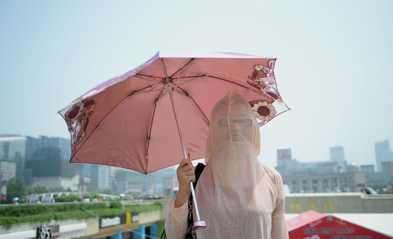 A woman wears her clothes backward against the scorching sun in Jinan, China, on August 4. 