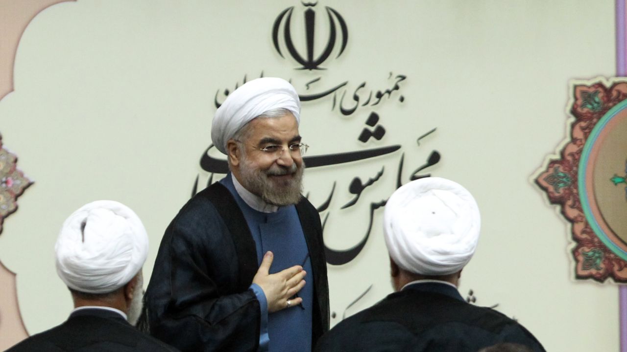 Iran's President Hasan Rowhani (C) arrives in parliament for his swearing-in ceremony in Tehran on August 4, 2013. The Islamic republic's new president revealed a cabinet lineup of experienced technocrats, aiming to deliver on his promise of saving the economy and engaging the world. AFP PHOTO/ATTA KENARE (Photo credit should read ATTA KENARE/AFP/Getty Images) 