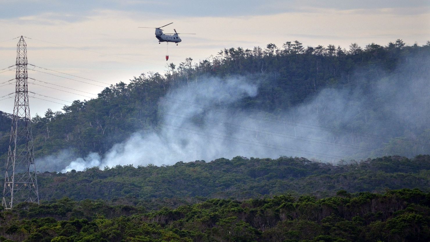 A U.S. military helicopter flies on a fire fighting operation after a U.S. military helicopter crashed on in Okinawa on August 5, 2013.