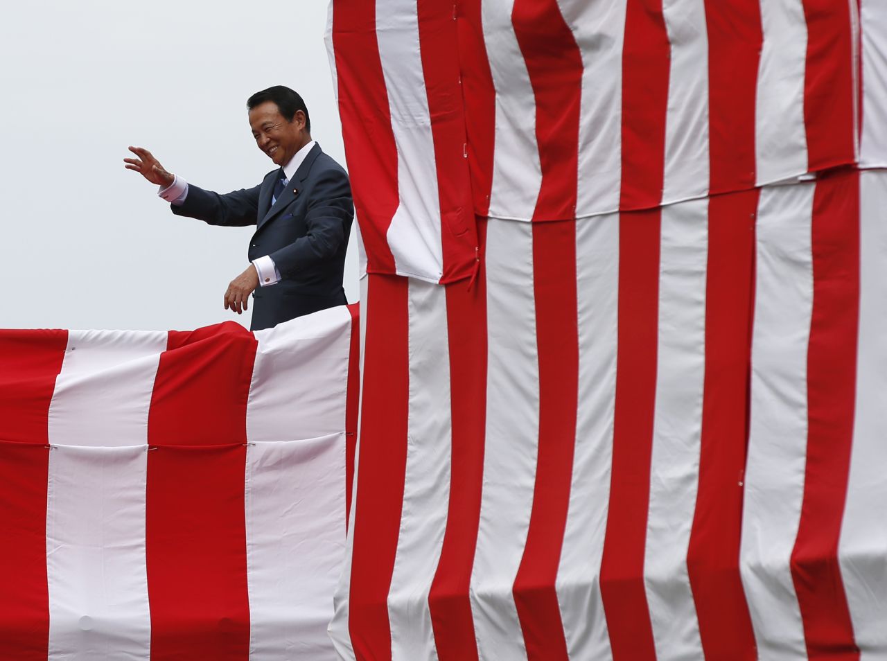 Taro Aso, Japan's deputy prime minister and finance minister, acknowledges the crowd during the launching ceremony.