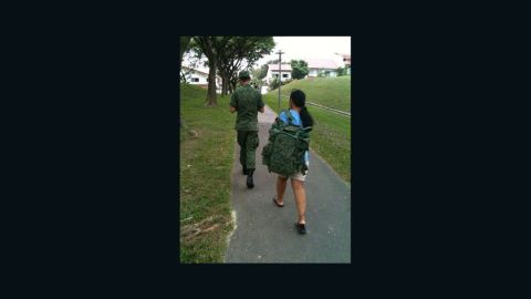 This picture of a maid carrying a SIngapore national serviceman's backpack went viral in 2011
