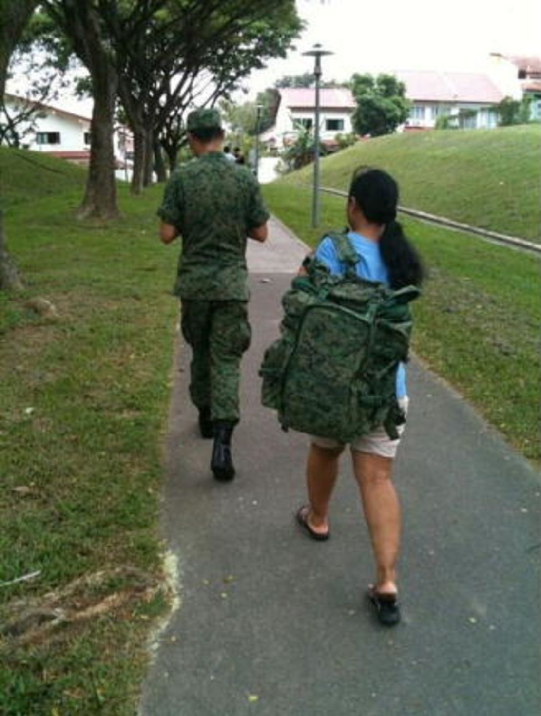 This picture of a maid carrying a SIngapore national serviceman's backpack went viral in 2011