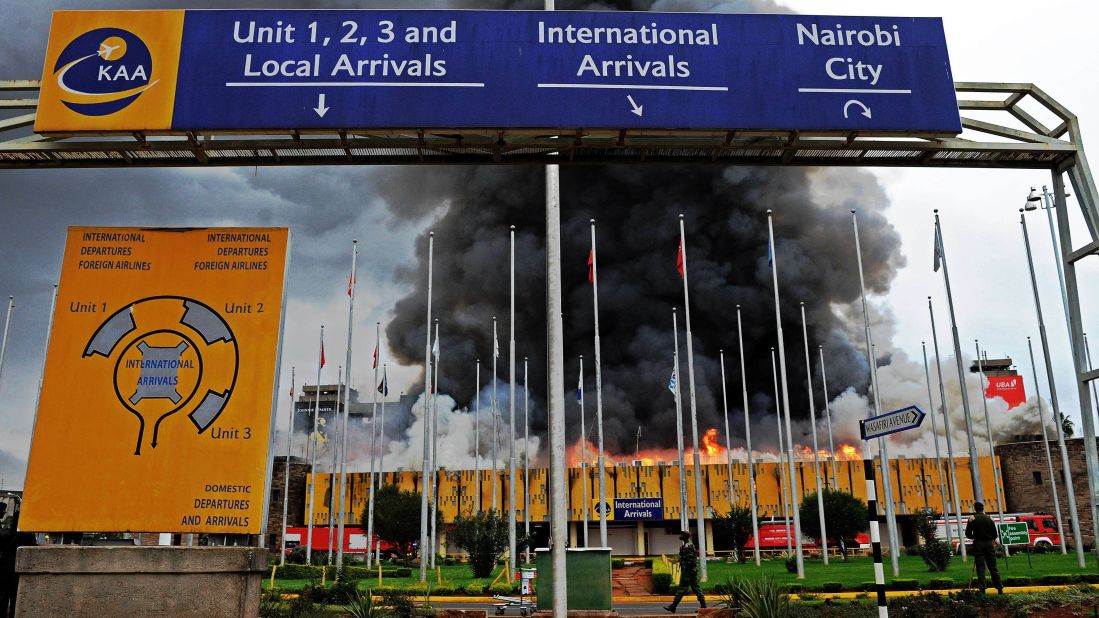 Authorities stand outside the burning airport on August 7.