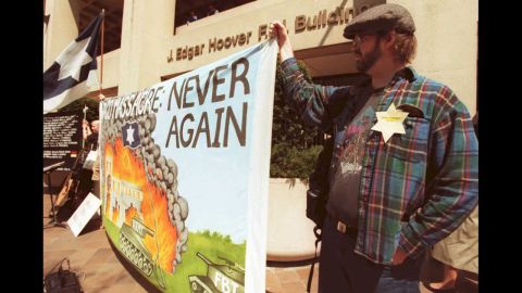 Andrew Williams holds up a sign depicting the scene at the Branch Davidian compound during a rally at the FBI Building in Washington on April 19, 1995. The rally was in remembrance of the Branch Davidians killed during the siege.