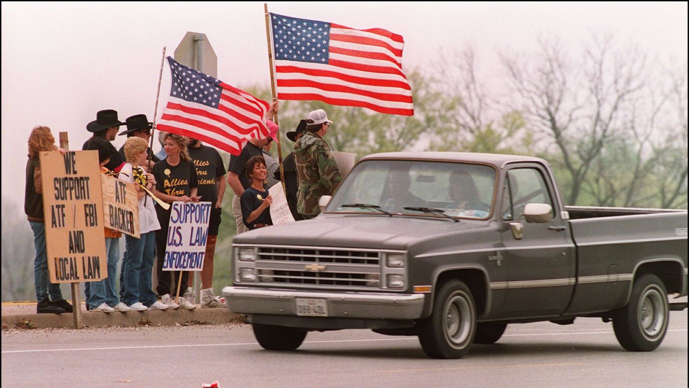 Supporters of the ATF stand beside the turnoff to the Branch Davidian compound on March 28, 1993.