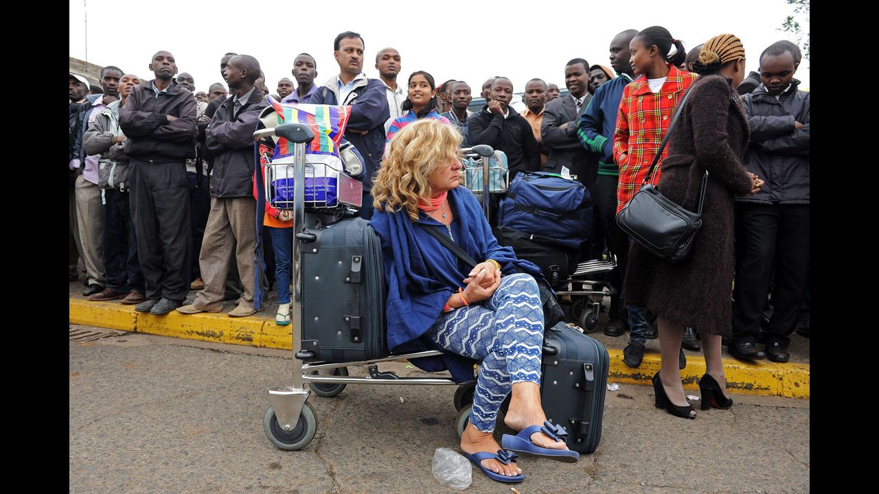 Stranded passengers wait outside the airport August 7.