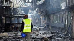An airport staff employee stands among the debris after a fire damaged a terminal at the Jomo Kenyatta international airport in Nairobi on August 7, 2013. 