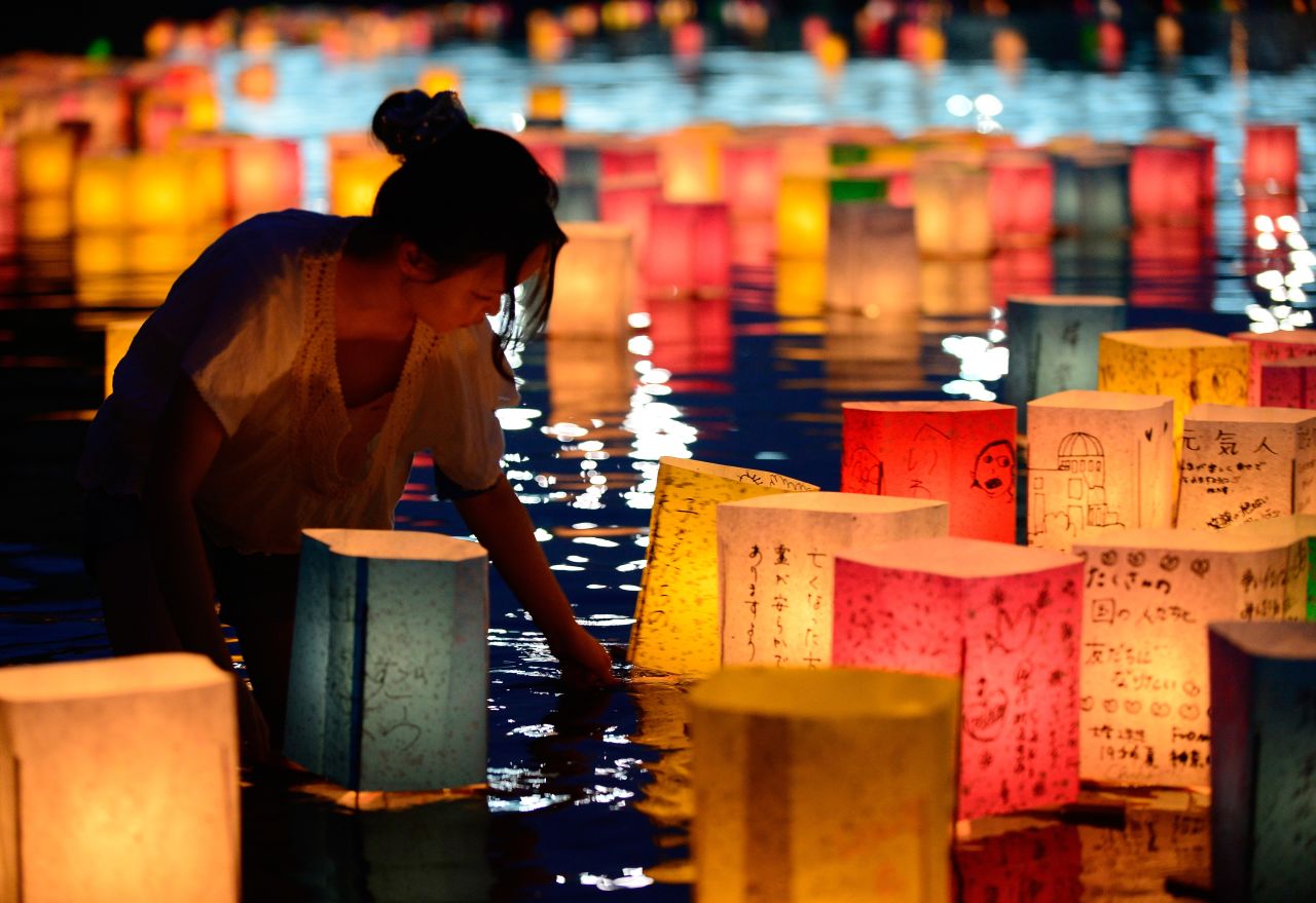 AUGUST 7 - HIROSHIMA, JAPAN: A woman floats paper lanterns on the Motoyasu River in memory of the victims of the 1945 atomic bombing of Hiroshima, western Japan. Crowds gathered in front of the Atomic Bomb Dome at the Peace Memorial Park in Hiroshima on August 6 to mark the 68th anniversary. The bombing <a href="http://cnn.com/2013/08/06/world/asia/btn-atomic-bombs/index.html?hpt=ias_mid">claimed the lives of more than 270,000 people.</a>