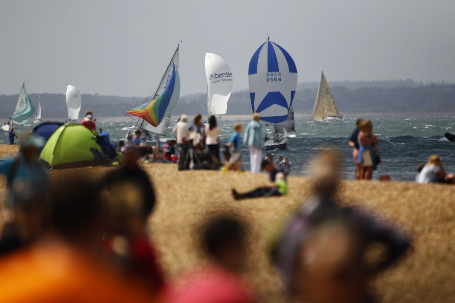 Spectators watch from the shore as yachts compete in Cowes Week,on the Isle of Wight in southern England. More than 8,000 sailors compete from around the world in the historic regatta.