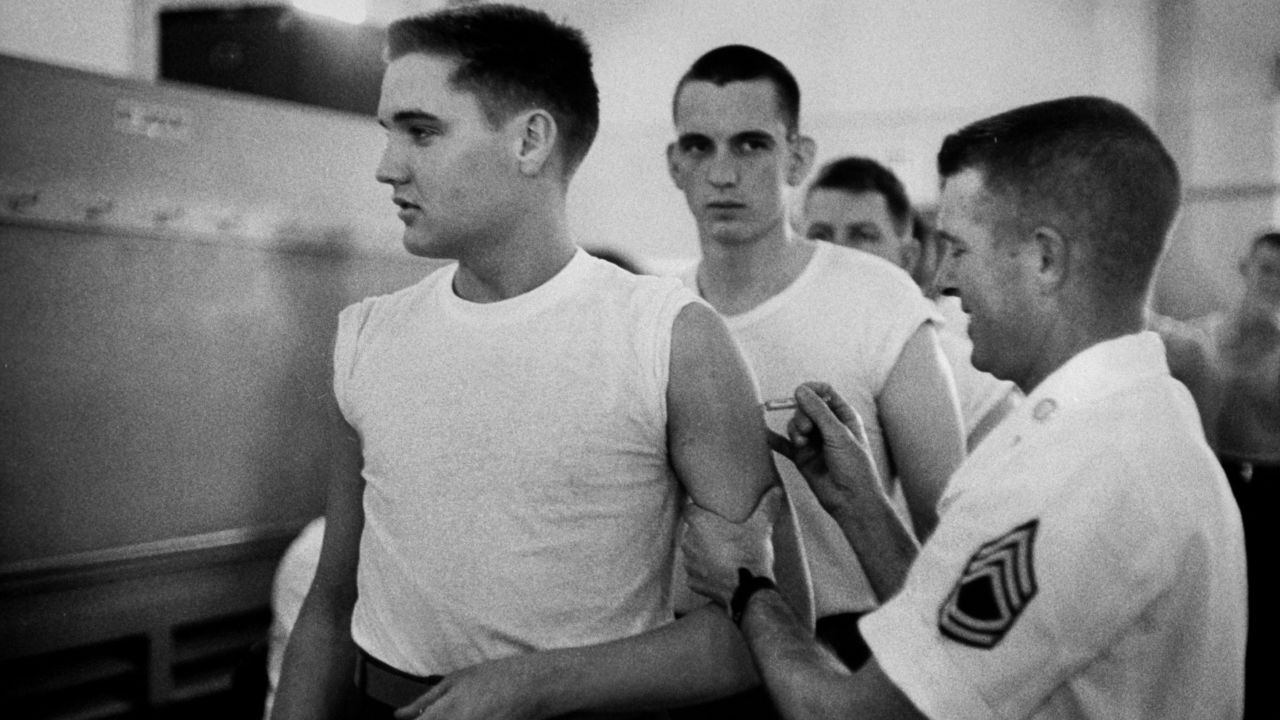 Presley, as a private in the US Army, receives a shot from at his pre-induction physical on March 26, 1958.