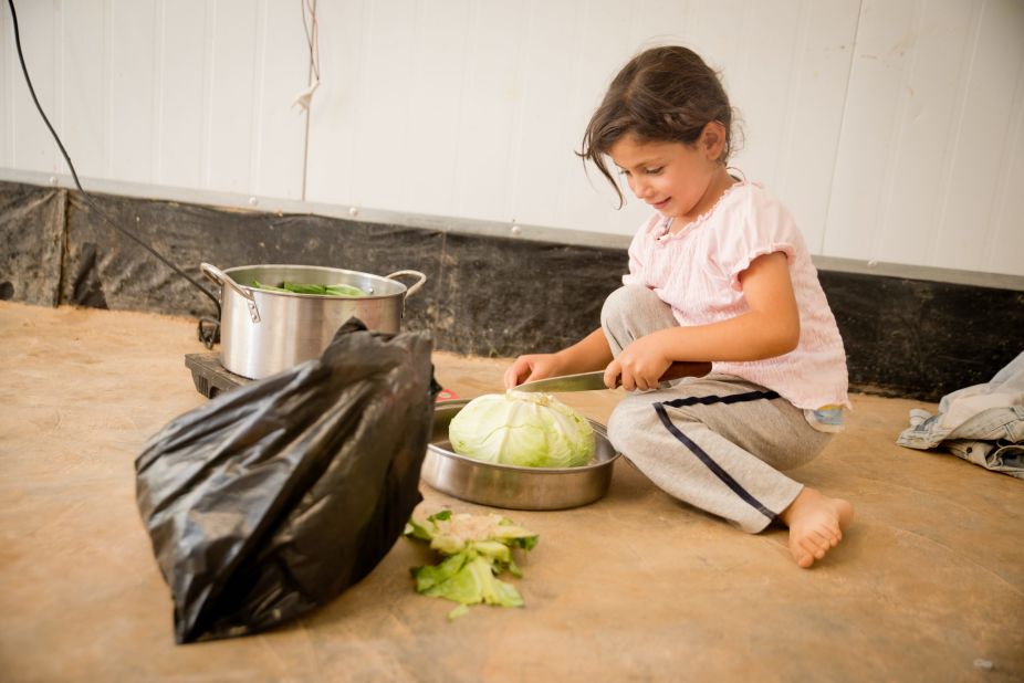 A young girl helps prepare the evening meal, <em>iftar</em>, with her family in Za'atari refugee camp. 