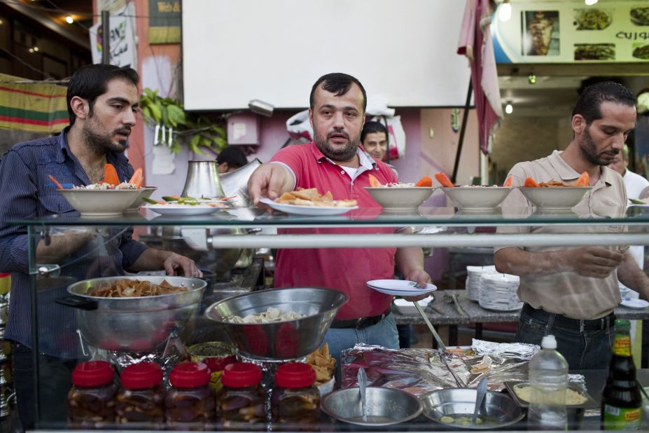 Syrian chef, Galal (center), prepares the evening iftar meal during Ramadan at the busy Bab Elhara Restaurant in Cairo. He fled to Egypt a month ago with his wife and two children.  <br />"I was away from Syria for eight years of my own free will, but now I'm away forcibly. As soon as things calm down, I will go back home," he said.