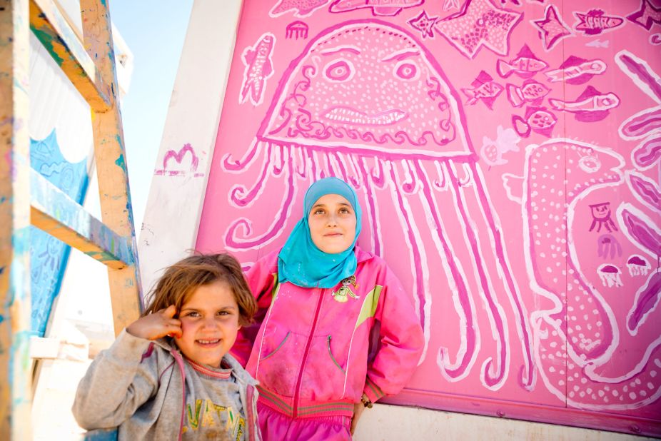 Two young Syrian girls at the Za'atari refugee camp in Jordan paint decorations on walls of the community bathrooms. "Doing this project helps us keep our minds off fasting," says 12 year old Sula (right), a refugee from a village outside Dara'a.