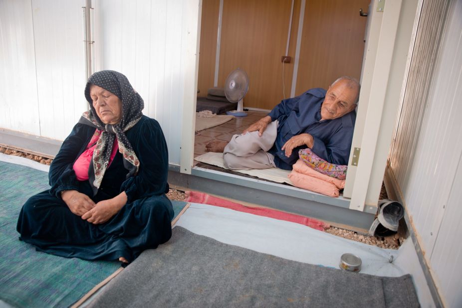 An elderly couple sits outside their caravan on a hot afternoon during Ramadan in Za'atari refugee camp in Jordan. The heat is challenging for the elderly, but many fast anyway.  