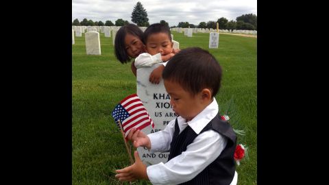 Kham Xiong's children visit their father's grave at Fort Snelling National Cemetery in Minnesota. Xiong was one of the 13 people killed in the Fort Hood shootings in 2009.