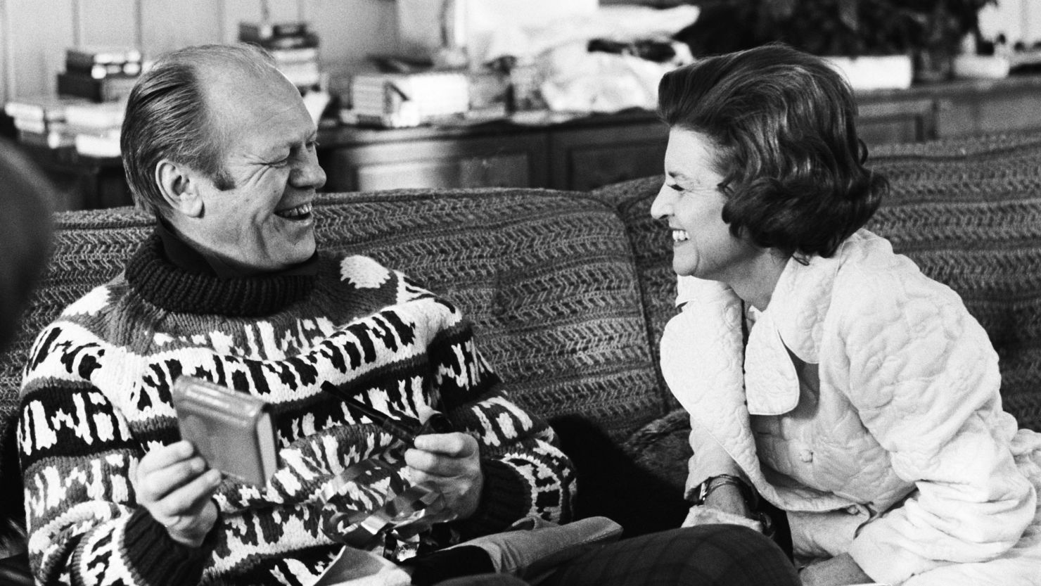 First Lady Betty Ford watches as her husband President Gerald R. Ford open his gift from her during the family's first visit of the presidency to their usual Christmas holiday vacation spot in Vail, Colorado. 