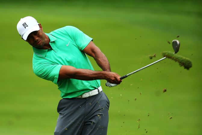Tiger Woods takes a big divot as he plays his approach shot to the second hole at Oak Hill on his way to a 70.