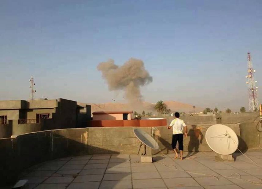 Smoke rising from a bomb attack in Tuz Khormato can be seen from a rooftop on August 10.