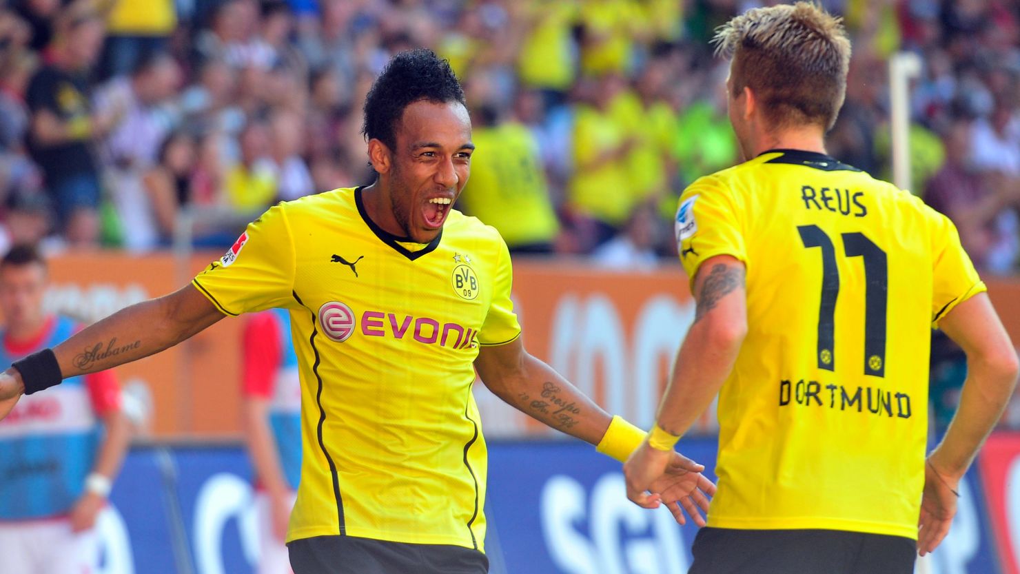 Pierre-Emerick Aubameyang celebrates with Marco Reus after scoring the second of his three goals against Augsburg. 