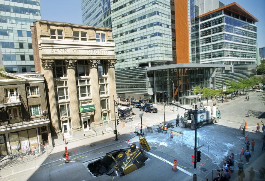 A backhoe is swallowed by a sinkhole in Montreal, Quebec, Canada, on August 6. The driver of the backhoe was not injured.