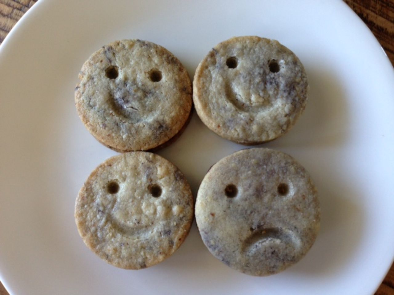 Las galletas de mantequilla de nuez con caritas tristes están rellenas de caramelo y ganache de chocolate.