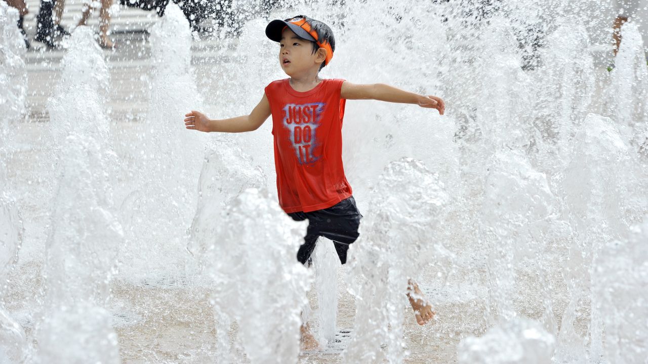 A South Korean boy plays in a fountain in Seoul on August 12.