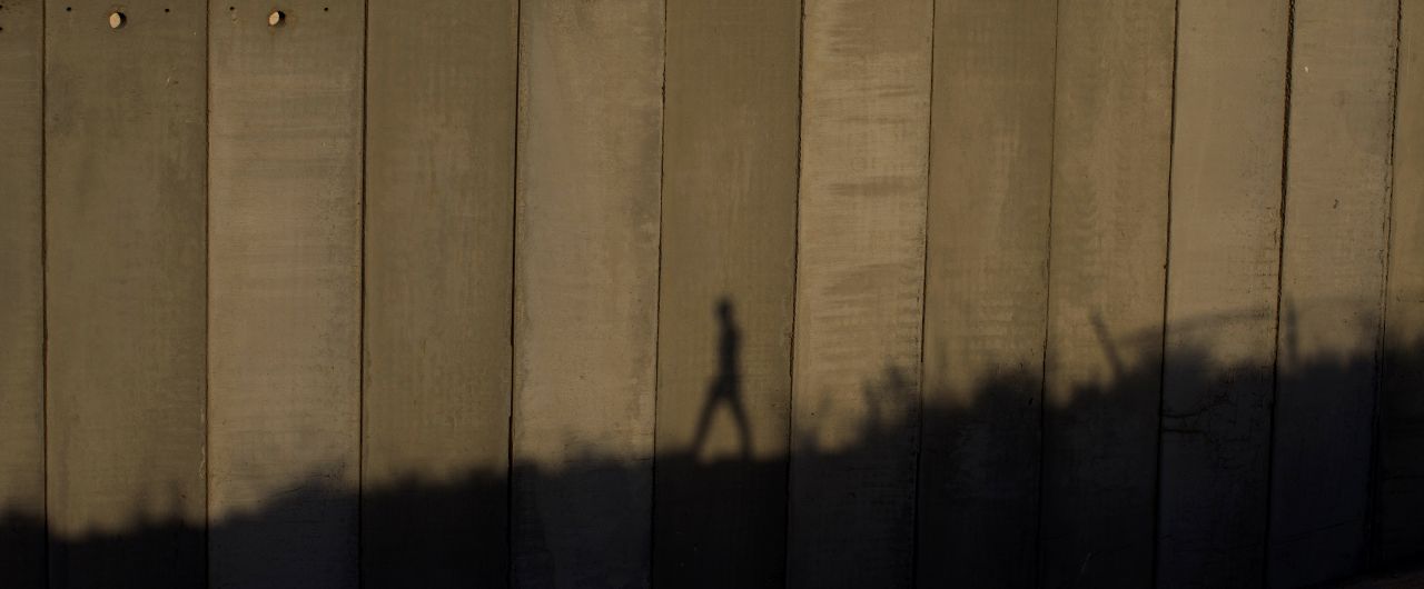 AUGUST 13 - JERUSALEM: A man walks past the separation wall near Jerusalem's Shuafat camp. The Israeli government approved the building of <a href="http://cnn.com/2013/08/13/world/meast/mideast-palestinians-israelis/index.html">900 new settlement units</a> in East Jerusalem on Tuesday -- the day before <a href="http://cnn.com/2013/07/19/world/meast/mideast-kerry-visit/index.html">peace talks with Palestinians</a> were set to resume. The move has drawn fire from critics who say construction on disputed territory could derail the talks.