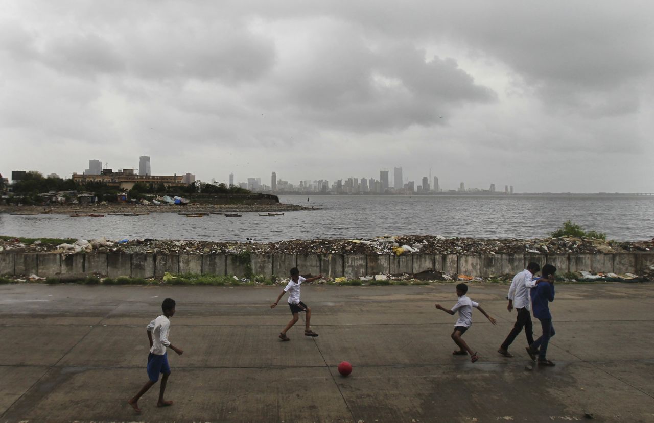 Indian children play soccer on the Arabian Sea coast as monsoon clouds hang low over Mumbai on Tuesday, August 13.