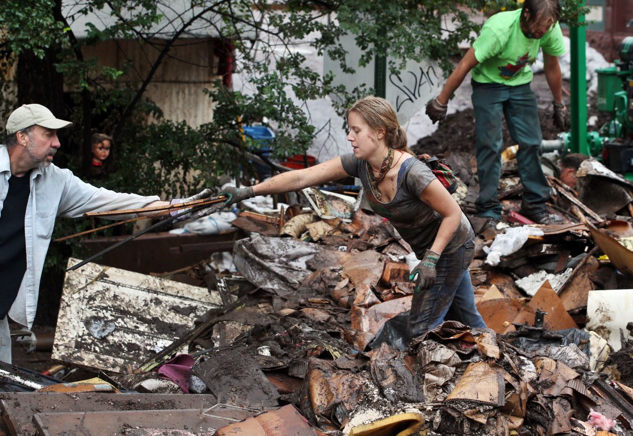 Erin Dettweiler, center, works with other local volunteers to clear away tons of mud-caked debris on August 13 after a recent <a href="http://www.cnn.com/2013/08/10/us/weather/index.html">flash flood in Manitou Springs, Colorado</a>.