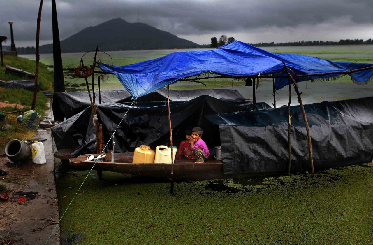 Children look out at the rain from under a makeshift shelter on August 13 in Srinagar, the summer capital of Kashmir.