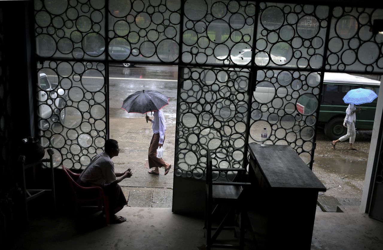 People make their way to work in the rainy weather in Yangon, Myanmar, on Monday, August 12.