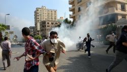 Morsy supporters run from tear gas in a street leading to Rabaa al-Adawiya mosque in Cairo on August 14.