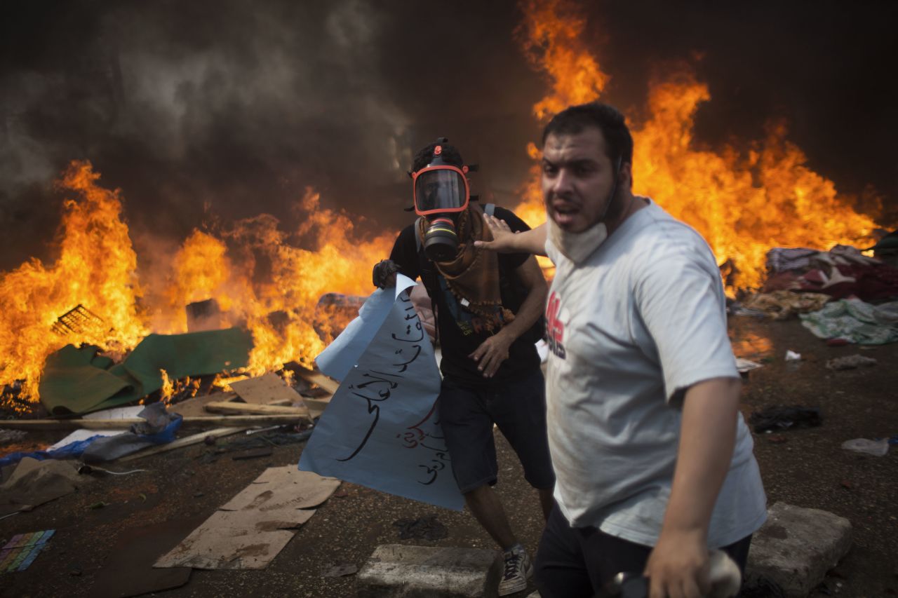 Supporters of ousted president Mohamed Morsy run as Egyptian security forces fire toward them on August 14, 2013.