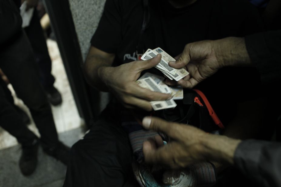 The national identity cards of protesters allegedly killed during a clear-out operation by Egyptian security forces on pro-Morsy demonstrators are exchanged at the Rabaa al-Adawiya Medical Center on August 14, 2013.