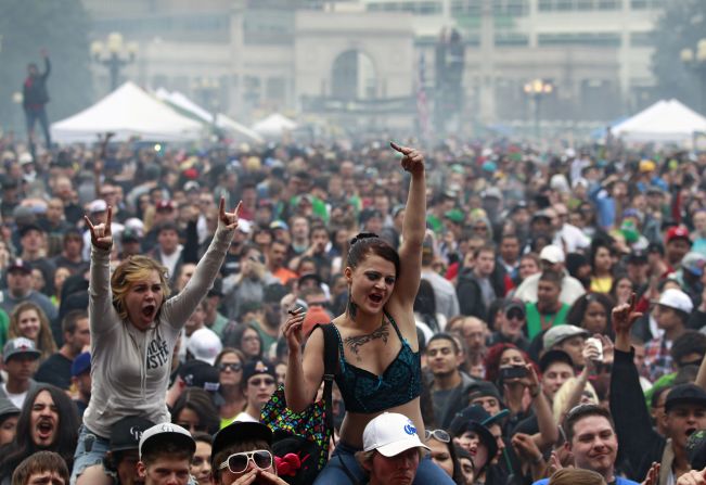 Members of a crowd numbering tens of thousands smoke and listen to live music at the Denver 420 Rally on April 20, 2013. <a href="index.php?page=&url=http%3A%2F%2Fwww.cnn.com%2F2013%2F04%2F20%2Fopinion%2Freiman-marijuana-day%2Findex.html">Annual festivals celebrating marijuana</a> are held around the world on April 20, a counterculture holiday.