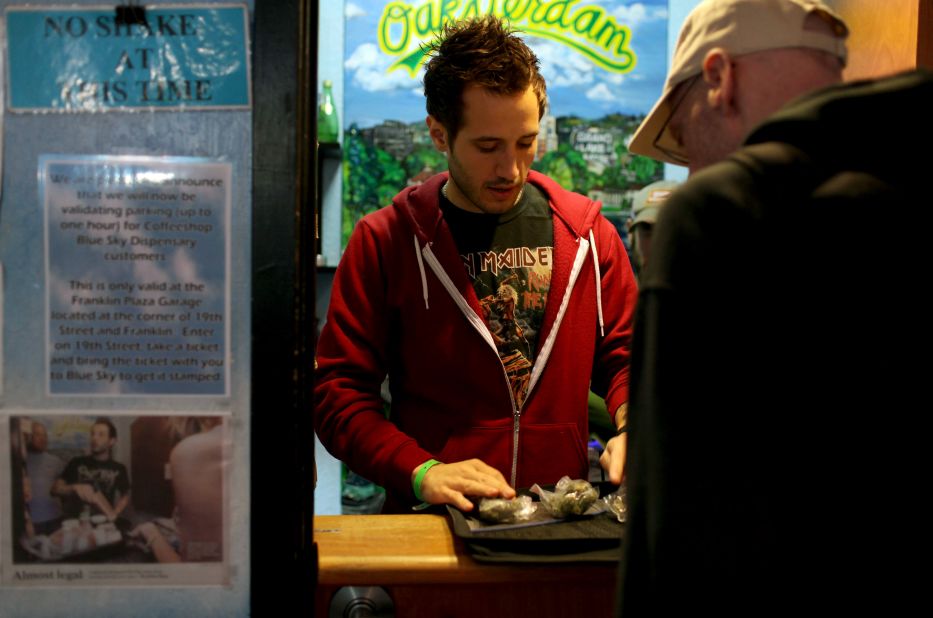Coffeeshop Blue Sky worker Jon Sarro, left, shows a customer different strains of medical marijuana on July 22, 2009, in Oakland, California. Voters in the city approved a measure during a vote-by-mail special election for a new tax on sales of medicinal marijuana at cannabis dispensaries.