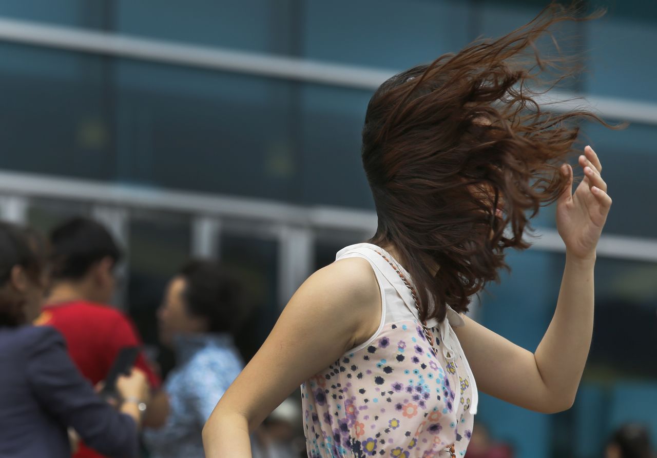 A visitor from mainland China braves the strong winds near the waterfront in Hong Kong on August 14. Typhoon Utor lashed Hong Kong with wind and rain, closing down the bustling Asian financial center before sweeping toward the mainland.