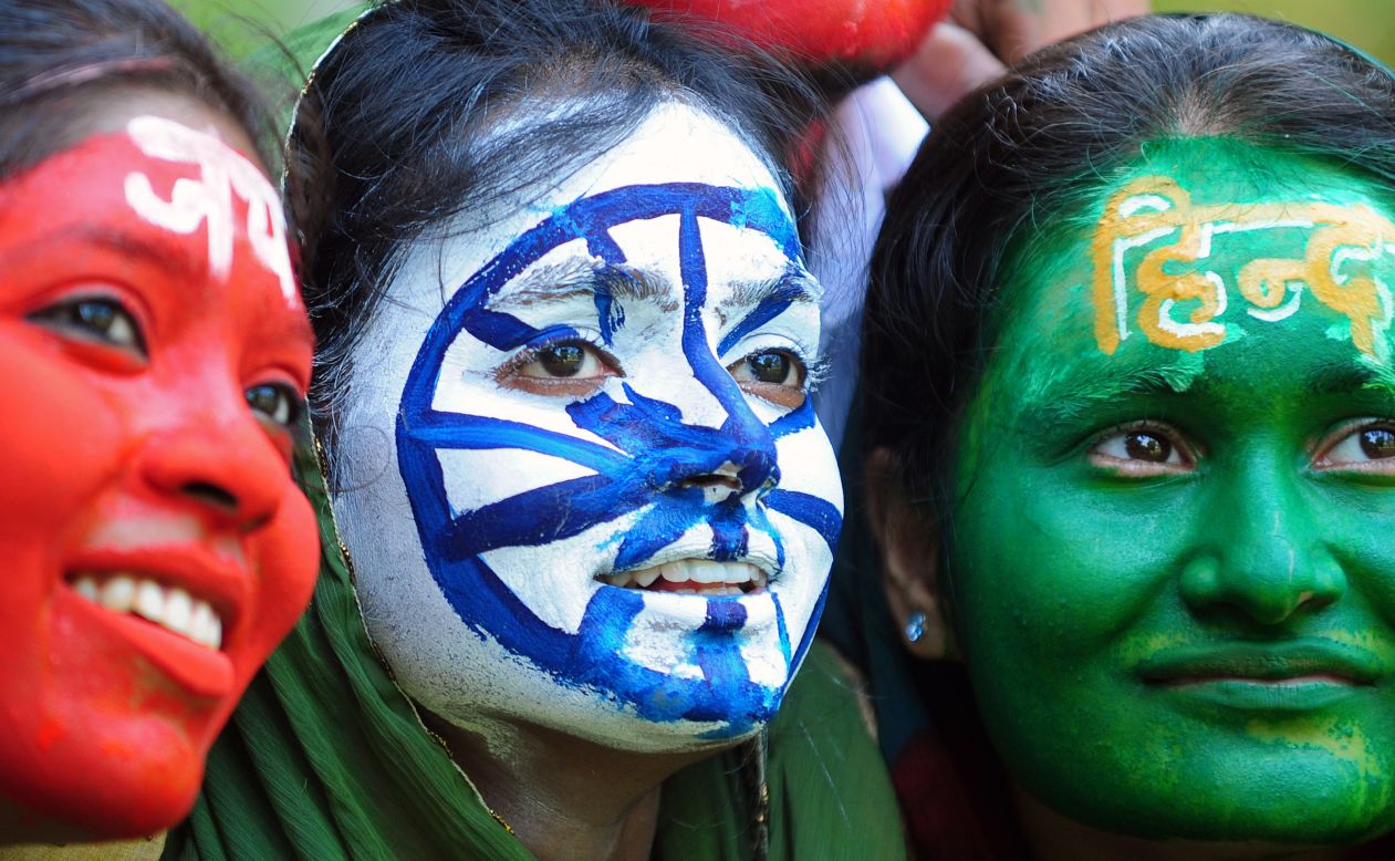 Indian students, their faces painted with the colours of their national flag, pose on the eve of Independence day in Allahabad on August 14, 2013. India celebrates its 66th independence anniversary from British rule on August 15.  