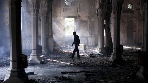 A man walks inside the burned-out Rabaa Al-Adawiya mosque in Cairo on August 15, 2013.