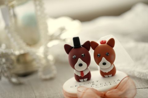Cake toppers, like these Welsh Corgis from"<a href="https://www.etsy.com/shop/kikuike?ref=si_shop" target="_blank" target="_blank">KIKUIKE</a>" help declare the happy couple's love for their pets.