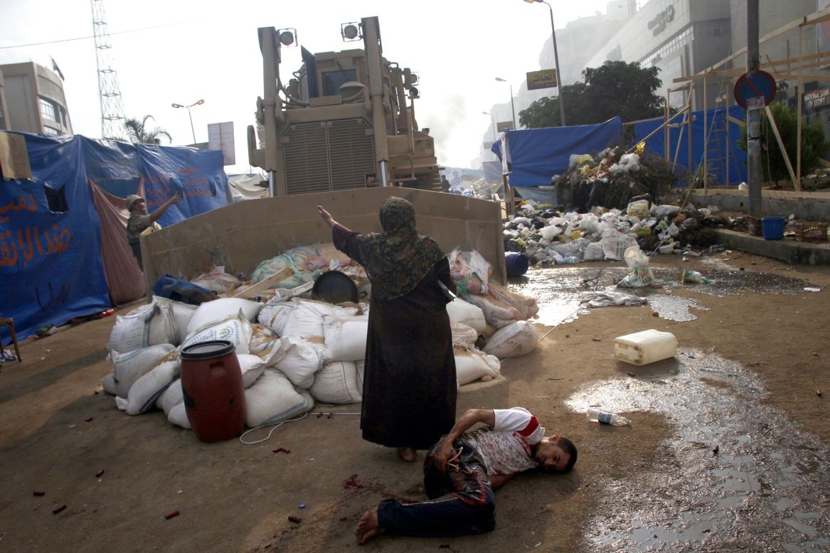 AUGUST 15 - CAIRO, EGYPT: A woman tries to stop a military bulldozer from hurting a wounded youth during clashes that broke out in Cairo. By the end of Wednesday, more than <a href="http://cnn.com/2013/08/15/world/meast/egypt-protests/index.htm">520 people were killed</a> and more than 3,500 injured in clashes in the country, the health ministry said.