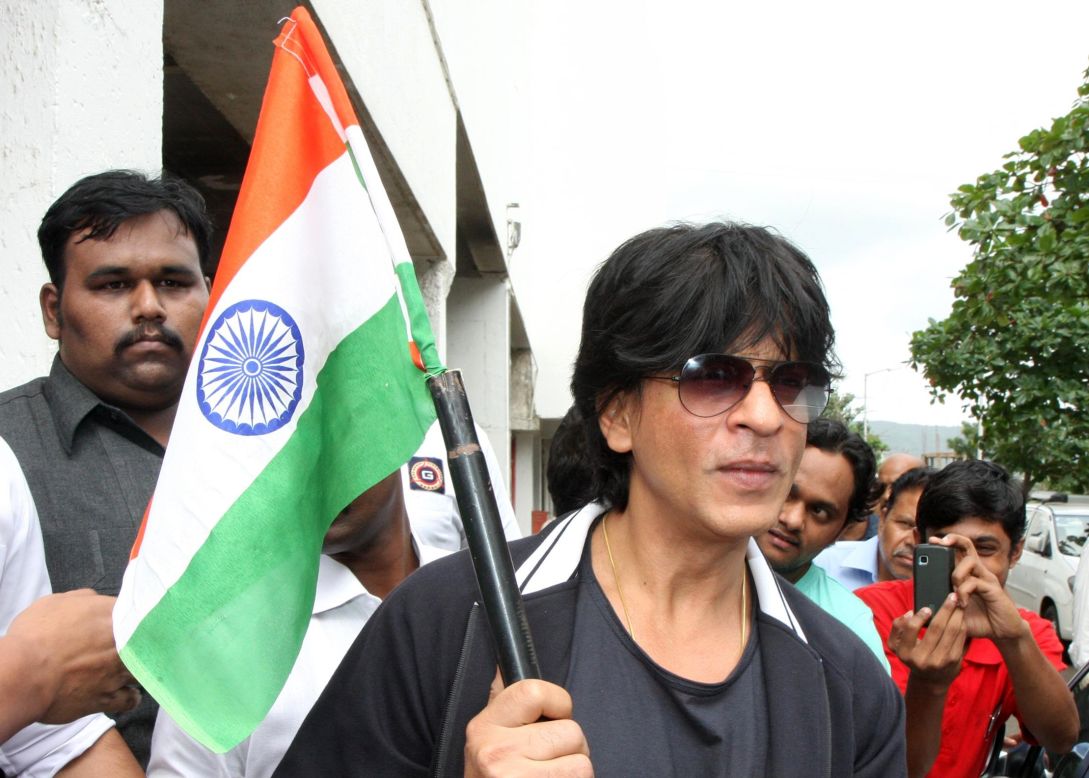 Indian Bollywood actor Shah Rukh Khan (center) poses with an Indian tricolour in Mumbai.