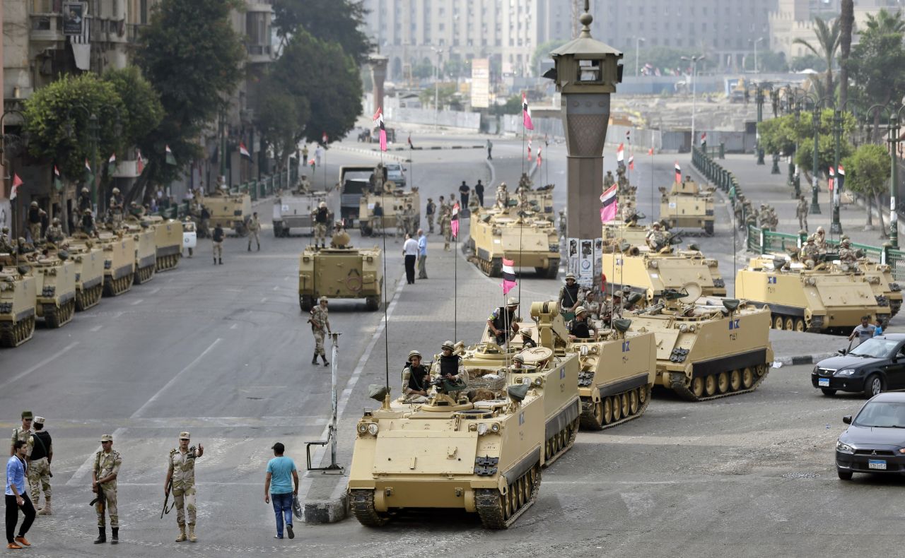 Egyptian soldiers take positions alongside armored vehicles as they guard the entrance to Tahrir Square in Cairo on Friday, August 16, 2013. 