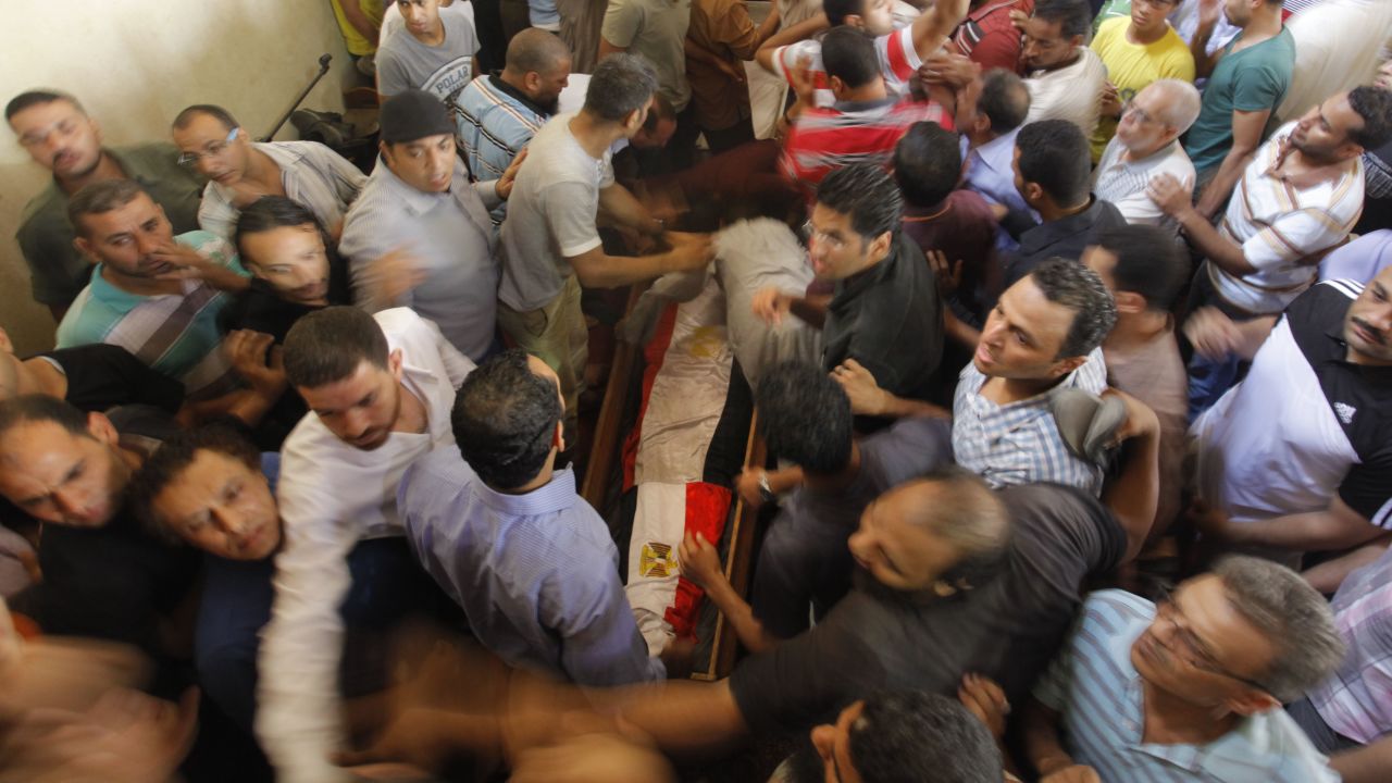 Supporters of Egypt's ousted President Mohammed Morsi surround a coffin, covered with national flags, of their colleague who was killed during Wednesday' clashes in Amr Ibn Al-As mosque before a funeral prayers in Cairo, Egypt, Friday, Aug. 16, 2013. Gunfire rang out over a main Cairo overpass and police fired tear gas as clashes broke out after tens of thousands of Muslim Brotherhood supporters took to the streets Friday across Egypt in defiance of a military-imposed state of emergency following the country's bloodshed earlier this week. (AP Photo/Amr Nabil)