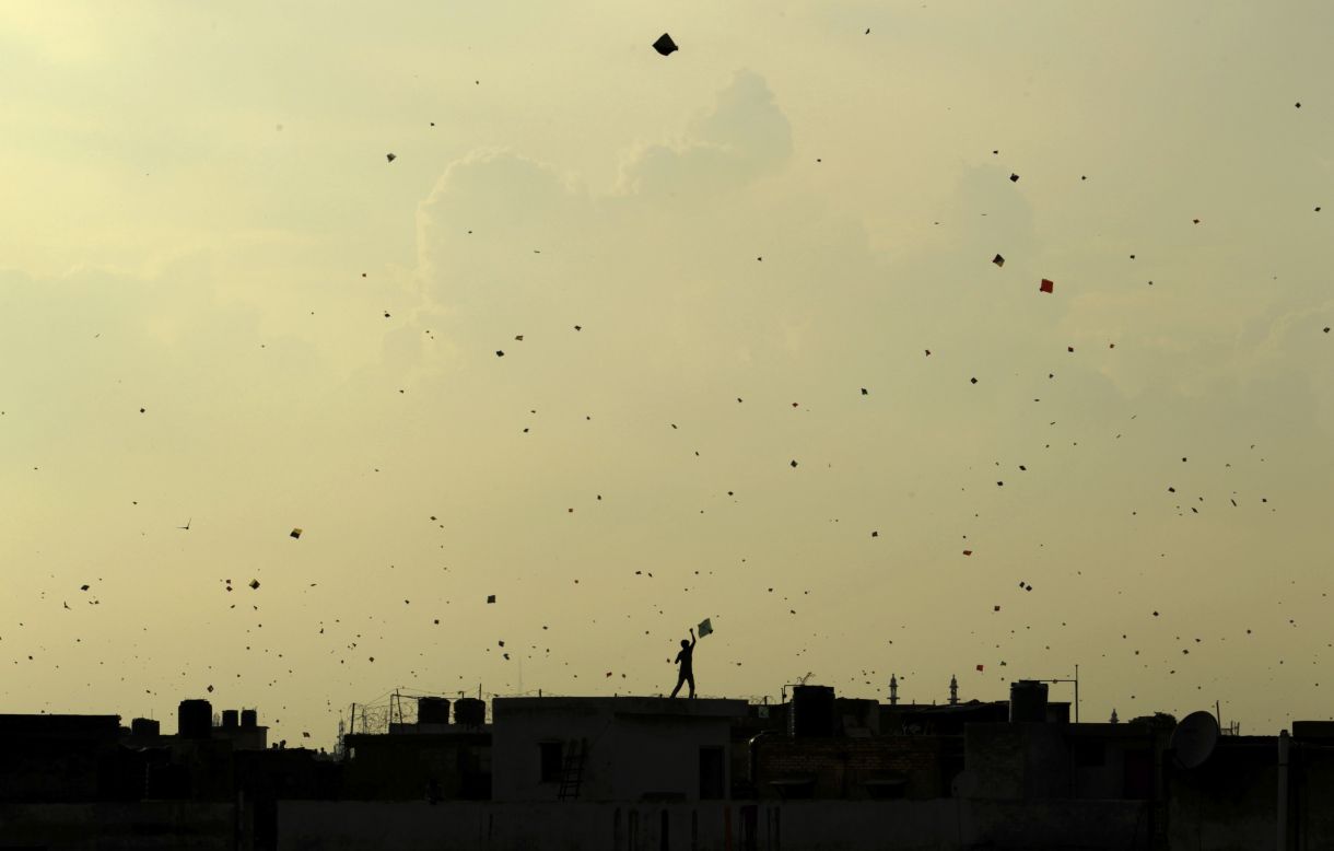 AUGUST 16 - NEW DELHI, INDIA: Against a yellowing sky, a boy stands on a roof and flies a kite, which flocks with other kites in traditional celebration of India's<a href="http://cnn.com/2013/08/15/world/asia/india-activists-independence-day-twitter/"> 66th Independence Day</a> on August 15. The day marks the end of the British rule on the country in 1947.