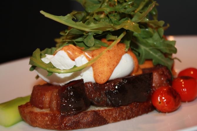 On the menu at the Mandarin Oriental Boston: A twist on the classic bacon and eggs combo includes two poached eggs, grilled and glazed thick cut bacon on grilled sourdough bread with roasted tomato arugula and smoked pimenton hollandaise.