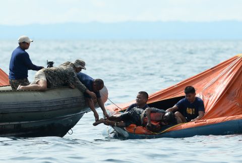 Philippine Navy personnel lift a victim from one of the floating life rafts during rescue operations on August 17. The two ships collided around 9 p.m. Friday.