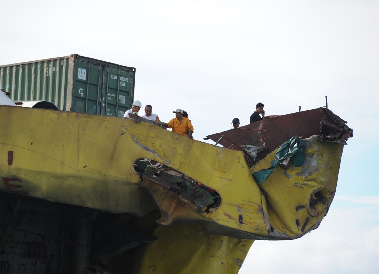 Crew members from the cargo ship inspect the damage to their ship on August 17.
